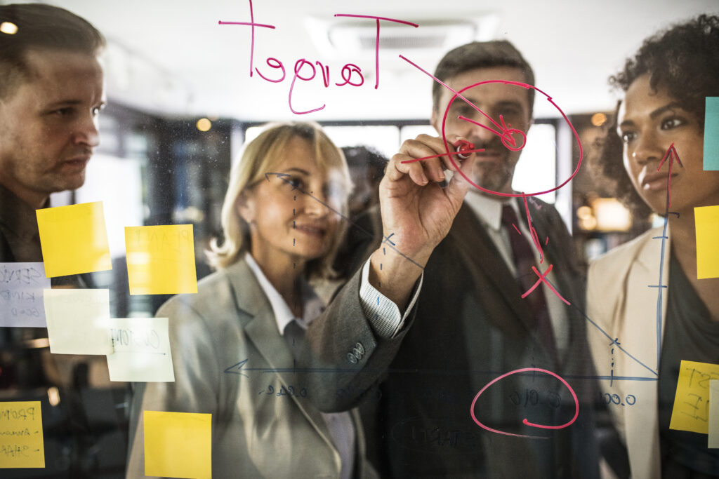 Businesspeople planning on a glass wall